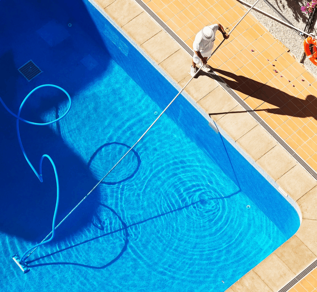 Person cleaning pool with vacuum