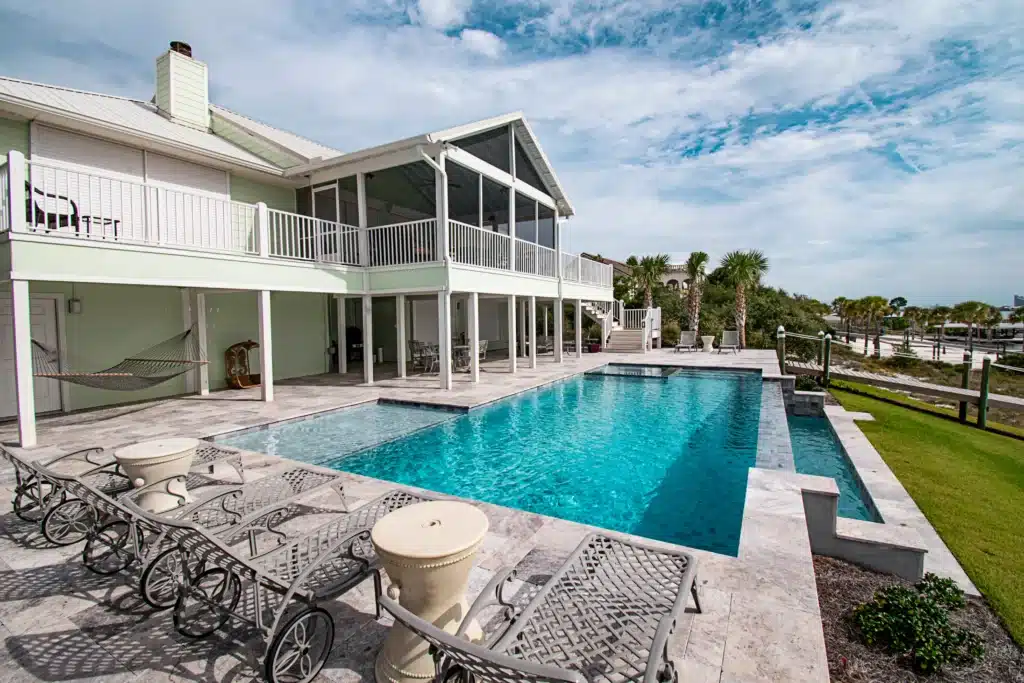 Seaside pool with chairs and scenic view of the coastline.